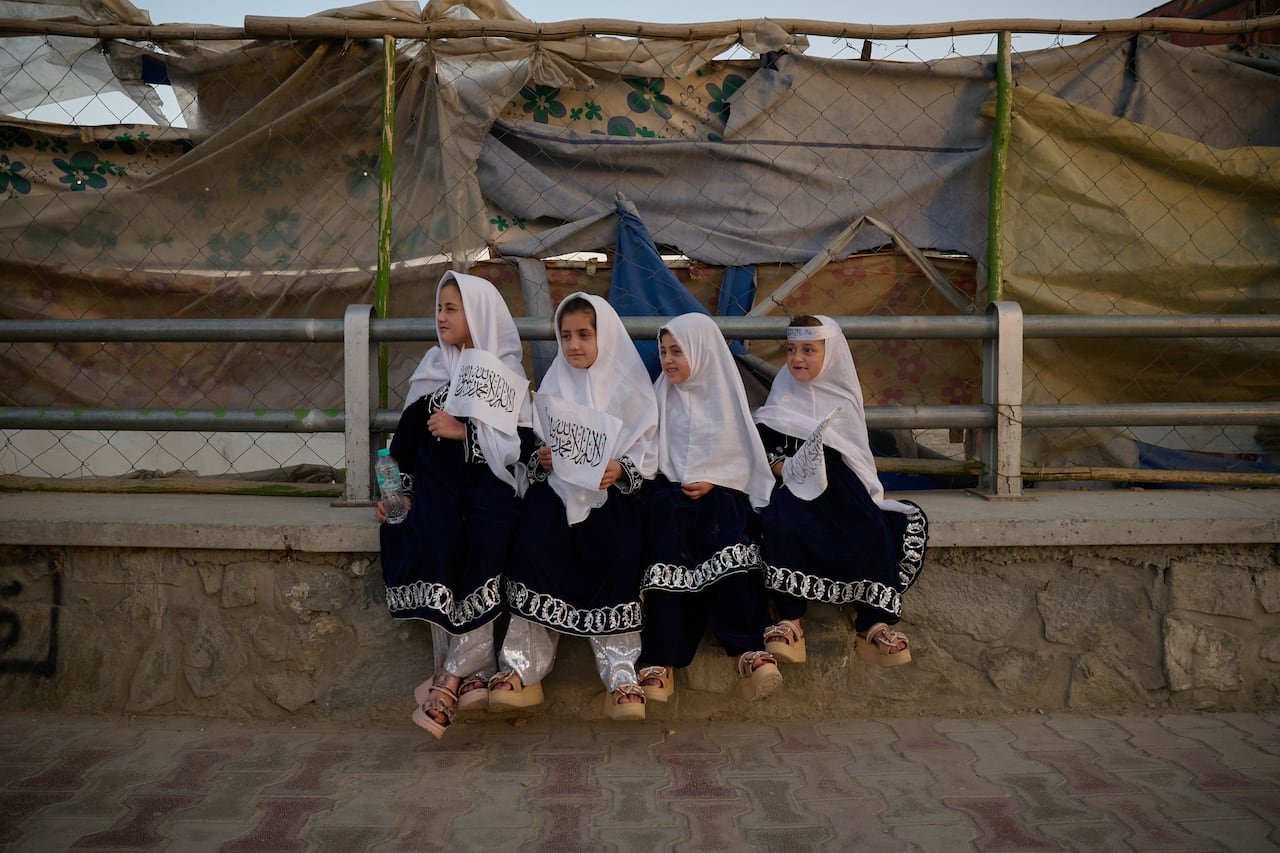 default-355 four girls sit in front of a concrete barrier